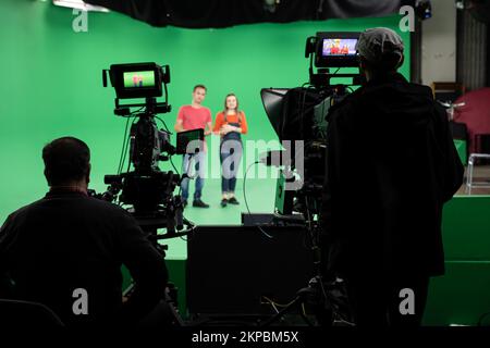 Licht... Kamera... Action! Woman and man-Moderator berichtet über Neuigkeiten im Studio. Film- und Fernsehindustrie. Stockfoto