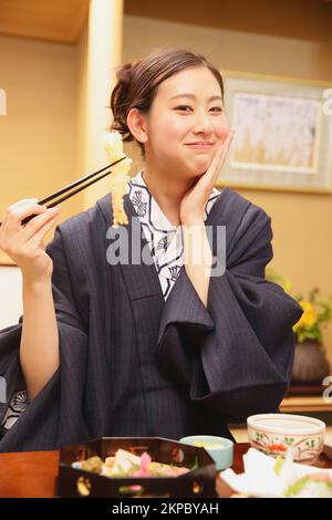Eine junge Japanerin isst zu Abend Stockfoto