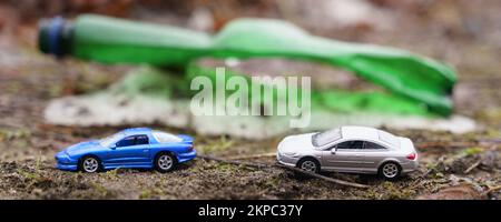 Umweltkonzept. Die Leute fahren im Urlaub im Hintergrund Autos Plastikflasche als Symbol der Verschmutzung. Stockfoto
