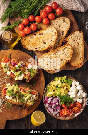 Leckere und gesunde Avocado, Kirschtomaten und Fetakäse-Sandwiches. Toasts mit Avocado, Tomaten und Fetakäse. Stockfoto