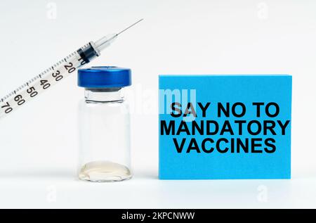Medizinisches Konzept. Auf dem Tisch sind eine Spritze, eine Injektion und ein blaues Schild mit der Inschrift - sagen Sie Nein zu obligatorischen Impfstoffen Stockfoto