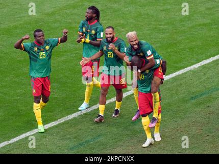 Der kamerunische Eric Maxim Choupo-Moting feiert das dritte Tor seiner Seite des Spiels auf dem Rücken des Mannschaftskollegen Vincent Aboubakar während des Gruppenspiels der FIFA-Weltmeisterschaft im Al Janoub Stadium in Al Wakrah, Katar. Foto: Montag, 28. November 2022. Stockfoto