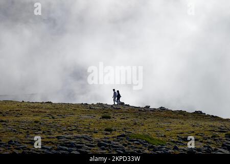 Touristen, die auf dem Gipfel der Serra da Estrela spazieren, dem höchsten Berg des kontinentalen Portugals mit dicken Wolken. Reisen und erkunden. Stockfoto