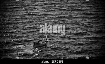 Frachtschiff auf See. Transitschiff. Segelboote. Fischerboot. Angeln. Besichtigungsboot. Boot, Schiff schwimmt in blauem Wasser. Sonnenbrand und Schiffsreflexion Stockfoto