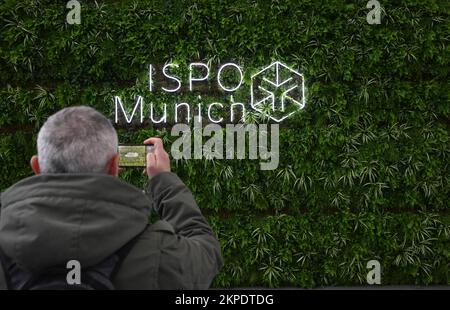 München, Deutschland. 28.. November 2022. Ein Besucher fotografiert das Logo der Sportmesse ISPO in der Eingangshalle der Messe München. Kredit: Felix Hörhager/dpa/Alamy Live News Stockfoto