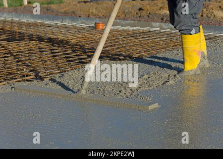 Bauarbeiter glättet Beton einer Bodenplatte Stockfoto