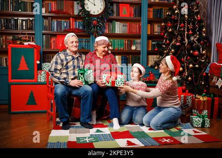 Glückliche große Familie, die zu Hause Weihnachtsgeschenke hält. Stockfoto