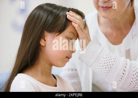 Japanisches Mädchen, das Fieber misst Stockfoto