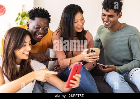 Eine Gruppe unterschiedlicher junger Menschen, die zu Hause Spaß mit dem Smartphone haben Stockfoto