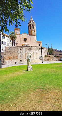 Graskreisel und Lampenmasten mit der Kirche San Bartolome und Santa Tecla im Hintergrund, Sitges, Barcelona, Katalonien, Spanien, Europa Stockfoto