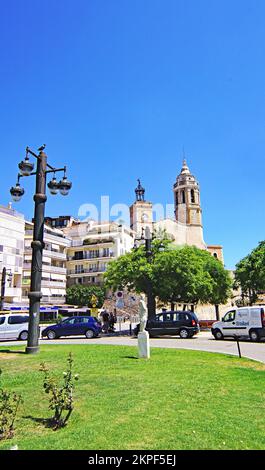 Graskreisel und Lampenmasten mit der Kirche San Bartolome und Santa Tecla im Hintergrund, Sitges, Barcelona, Katalonien, Spanien, Europa Stockfoto