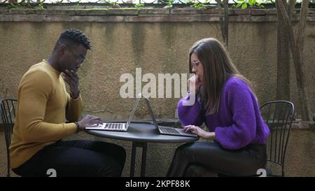 Ein vielseitiges junges Paar, das ein Notebook zusammen verwendet Stockfoto