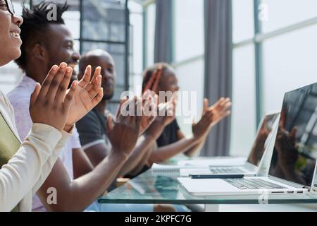 Multi-ethnische Gruppe grüßt jemand mit Klatschen und lächelnd Stockfoto