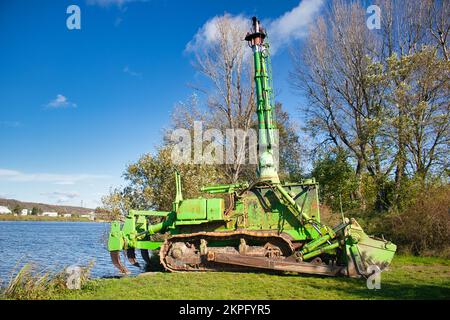 Komatsu-Amphibiendozer am Flussufer im Herbst. Stockfoto