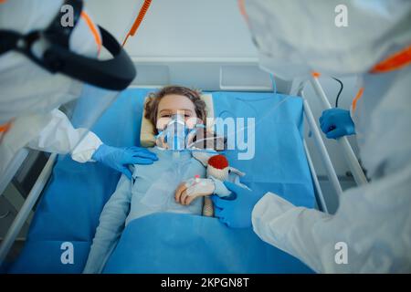 Nahaufnahme eines kleinen Mädchens mit Infektionskrankheit, das im Krankenhauszimmer liegt. Stockfoto