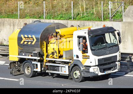 Volvo LKW-Fahrgestellkabine und Spezialausrüstung aus Bitumentank für Straßensprühen Nutzfahrzeugführer im Fahrerhaus Fahren auf britischen Autobahnen Stockfoto