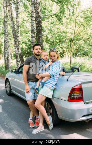 Mama, Papa und kleiner Sohn in einem Cabriolet. Sommer Familienausflug in die Natur Stockfoto