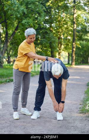 Ältere Ehepaare trainieren, trainieren draußen. Gesunder, sportlicher Lebensstil oder Rentner-Konzept Stockfoto