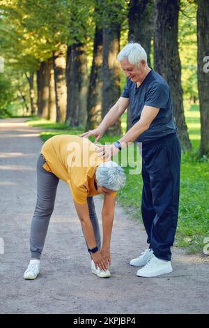 Ältere Ehepaare trainieren, trainieren draußen. Gesunder, sportlicher Lebensstil oder Rentner-Konzept Stockfoto