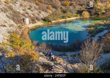 Touristen in der Nähe der Süßwasserquelle des Flusses Cetina in Kroatien. Informationsschalter von Cetina Spring. Stockfoto