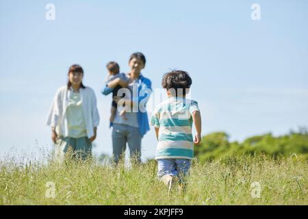 Japanische Eltern, die auf das laufende Kind aufpassen Stockfoto