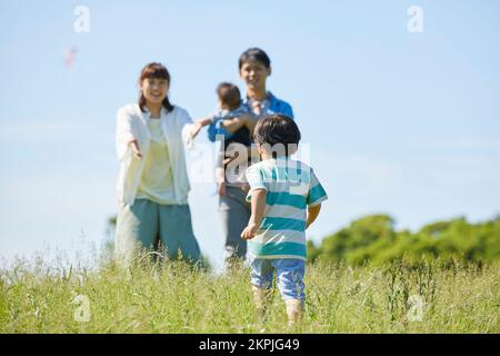 Japanische Eltern, die auf das laufende Kind aufpassen Stockfoto