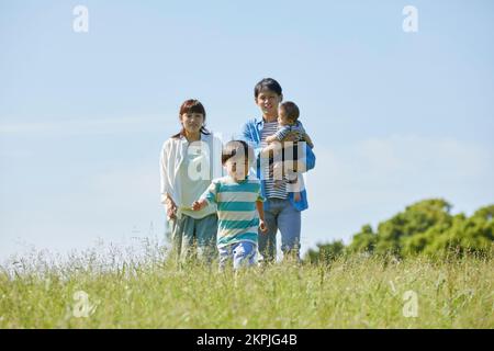 Japanische Eltern, die auf ein laufendes Kind aufpassen Stockfoto