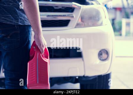 Maschinenbautechniker halten Motorschmieröl in der Hand, entfernen schwebende Verunreinigungen und Schlamm, um den Motor sauberer und reibungsloser zu halten Stockfoto