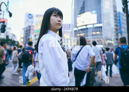 Japanisches Highschool-Mädchen bei Shibuya Scramble Crossing Stockfoto