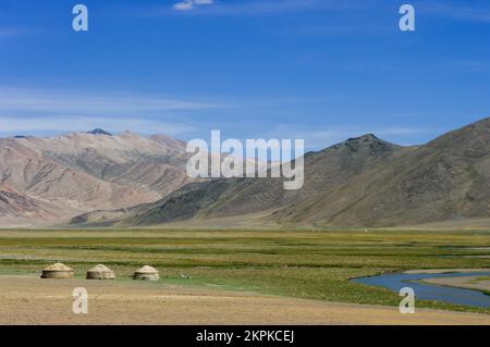 Berglandschaft mit Fluss und Kirgisischen nomadischen Jurten auf Sommerweiden entlang der hoch gelegenen Pamir Highway in der Nähe von Murghab, Gorno-Badakshan, Tadschikistan Stockfoto