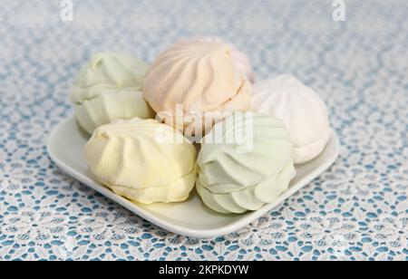 Köstlicher, bunter Marshmallow liegt auf einem Kosmetiktisch in der Untertasse Stockfoto