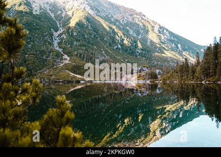 Morskie Oko oder Sea Eye Lake im Herbst, Tatra-Nationalpark, in der Nähe von Zakopane, Polen. Blick auf hölzerne Berghütte, altes Haus, Schutz am See. Stockfoto