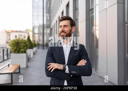 Ein glücklicher, gutaussehender, junger europäischer CEO oder General Director mit Bart im Anzug Stockfoto