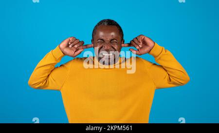 afroamerikaner reifer Mann, der Ohren mit Fingern zustopft Stockfoto