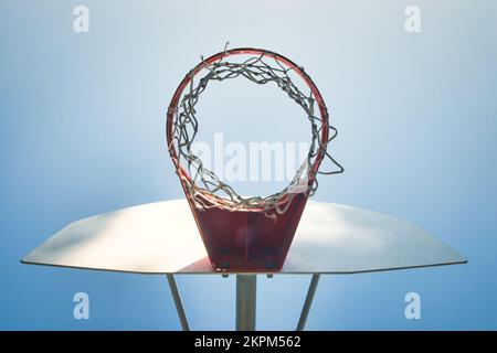 Niedriger Winkel mit Blick auf Basketballkorb, Netz und Rückwand vor blauem Himmel Stockfoto