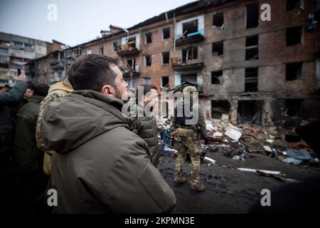 Der ukrainische Präsident Wolodymyr Zelensky besuchte die Stadt Wyschgorod, Region Kiew, auf einer Arbeitsreise und inspizierte ein vierstöckiges Wohngebäude, das am 23. November durch einen russischen Raketenangriff beschädigt wurde. Oleksiy Kuleba, Leiter der regionalen Militärverwaltung Kiew, berichtete dem Staatschef über das Ausmaß der Zerstörung durch eine russische Rakete, die das Gebäude traf. Bei diesem Anschlag wurden sechs Menschen getötet und mindestens 30 Menschen verletzt. Die Opfer erhalten die notwendige medizinische Versorgung. (Foto: Büro des ukrainischen Präsidenten) Stockfoto