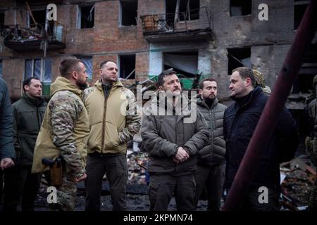 Der ukrainische Präsident Wolodymyr Zelensky besuchte die Stadt Wyschgorod, Region Kiew, auf einer Arbeitsreise und inspizierte ein vierstöckiges Wohngebäude, das am 23. November durch einen russischen Raketenangriff beschädigt wurde. Oleksiy Kuleba, Leiter der regionalen Militärverwaltung Kiew, berichtete dem Staatschef über das Ausmaß der Zerstörung durch eine russische Rakete, die das Gebäude traf. Bei diesem Anschlag wurden sechs Menschen getötet und mindestens 30 Menschen verletzt. Die Opfer erhalten die notwendige medizinische Versorgung. (Foto: Büro des ukrainischen Präsidenten) Stockfoto