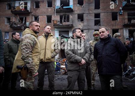 Der ukrainische Präsident Wolodymyr Zelensky besuchte die Stadt Wyschgorod, Region Kiew, auf einer Arbeitsreise und inspizierte ein vierstöckiges Wohngebäude, das am 23. November durch einen russischen Raketenangriff beschädigt wurde. Oleksiy Kuleba, Leiter der regionalen Militärverwaltung Kiew, berichtete dem Staatschef über das Ausmaß der Zerstörung durch eine russische Rakete, die das Gebäude traf. Bei diesem Anschlag wurden sechs Menschen getötet und mindestens 30 Menschen verletzt. Die Opfer erhalten die notwendige medizinische Versorgung. (Foto: Büro des ukrainischen Präsidenten) Stockfoto