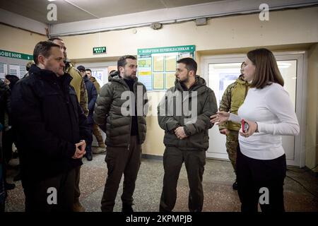 Der ukrainische Präsident Wolodymyr Zelensky besuchte die Stadt Wyschgorod, Region Kiew, auf einer Arbeitsreise und inspizierte ein vierstöckiges Wohngebäude, das am 23. November durch einen russischen Raketenangriff beschädigt wurde. Oleksiy Kuleba, Leiter der regionalen Militärverwaltung Kiew, berichtete dem Staatschef über das Ausmaß der Zerstörung durch eine russische Rakete, die das Gebäude traf. Bei diesem Anschlag wurden sechs Menschen getötet und mindestens 30 Menschen verletzt. Die Opfer erhalten die notwendige medizinische Versorgung. (Foto: Büro des ukrainischen Präsidenten) Stockfoto