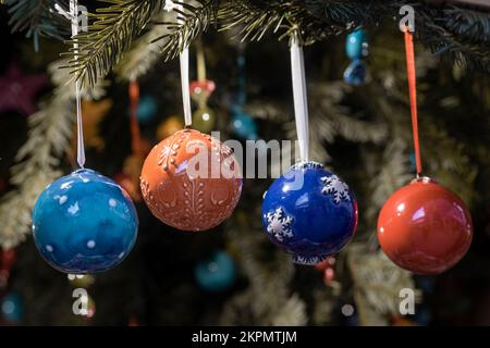 Farbenfrohe Weihnachtsbälle und Ornamente, die während des Adventsjahrs an einem Zweig des Weihnachtsbaums hängen Stockfoto