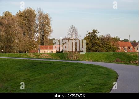 Berlare, Ostflämische Region, Belgien, 11 03 2022 - Blick auf einen biegsamen Radweg und den Kirchturm Stockfoto