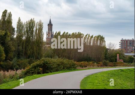 Wetteren, Ostflämische Region, Belgien, 11 03 2022 - Blick über einen biegsamen Radweg und den Kirchturm Stockfoto Wetteren, Ostflämische Region, Belgien, 11 03 2022 - Blick über einen biegsamen Radweg und den Kirchturm Stockfoto