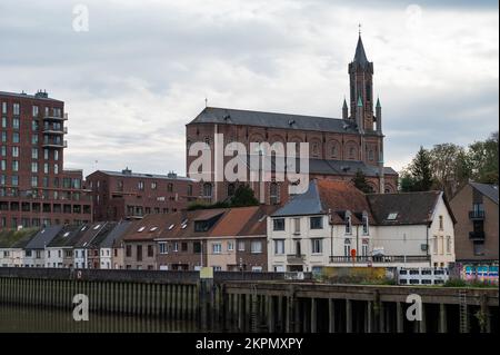 Wetteren, Ostflämische Region, Belgien, 11 03 2022 - Blick über das Dorf, die Wohnblocks und die Kirche vom Ufer der Schelde Stockfoto Wetteren, Ostflämische Region, Belgien, 11 03 2022 - Blick über das Dorf, die Wohnblocks und die Kirche vom Ufer der Schelde Stockfoto