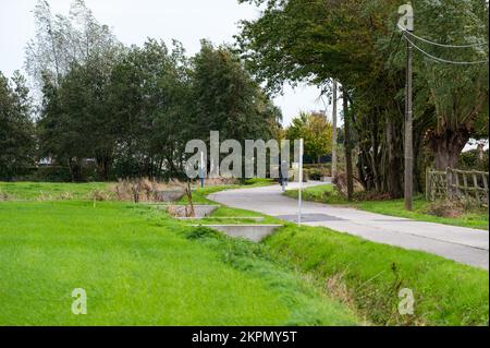 Laarne, Ostflämische Region, Belgien, 11 03 2022 - Grüne Umgebung und ein Radweg in der flämischen Landschaft Stockfoto