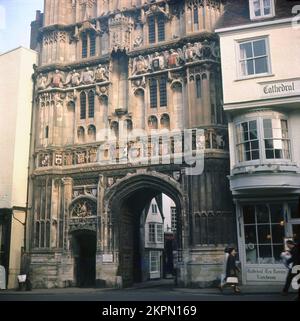 1960er, historisch, Außenansicht des Canterbury Cathedral Gate, Canterbury, Kent, England, Großbritannien. Das Christuskirchentor im alten Buttermarkt wurde zwischen 1504 und 1521 erbaut und ist mit heraldischen Motiven, Wappen und mythischen Tieren verziert und dekoriert. Zu dieser Zeit war das Zentrum, über dem Torbogen, leer, da es ursprünglich eine christusstatue enthielt, die 1642 zerstört wurde. Stockfoto