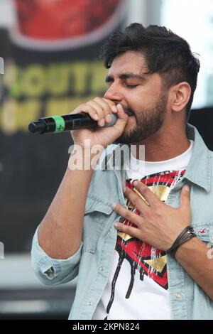 August 2013, Mississauga, Ontario, Kanada. --- Leadsänger Sups der britischen Band Swami belebt das Publikum, während Swami beim Mosaik 2013 South Asian Heritage Festival in Mississauga auftritt. Swami kombiniert Punjabi, Hindi und Englisch und kombiniert Bhangra, Rock und Rap zu einem einzigartigen Musikstil, der sich im gesamten Vereinigten Königreich ausgebreitet hat. Ihr Sound ist eine perfekte Hommage an die unabhängige Punjabi-Musik, die sich in Großbritannien in den letzten 30 Jahren entwickelt hat. --- (Foto von Creative Touch Imaging Ltd./NurPhoto)0 Stockfoto