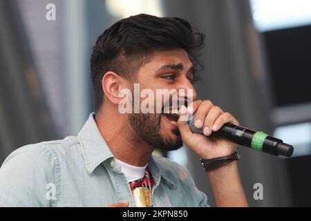 August 2013, Mississauga, Ontario, Kanada. --- Leadsänger Sups der britischen Band Swami belebt das Publikum, während Swami beim Mosaik 2013 South Asian Heritage Festival in Mississauga auftritt. Swami kombiniert Punjabi, Hindi und Englisch und kombiniert Bhangra, Rock und Rap zu einem einzigartigen Musikstil, der sich im gesamten Vereinigten Königreich ausgebreitet hat. Ihr Sound ist eine perfekte Hommage an die unabhängige Punjabi-Musik, die sich in Großbritannien in den letzten 30 Jahren entwickelt hat. --- (Foto von Creative Touch Imaging Ltd./NurPhoto) Stockfoto