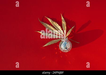 Abstrakter weihnachtshintergrund mit verspiegelter Discokugel und goldenem Marihuana-Blatt. Weihnachtskonzept für Poster und Banner zur Werbung für Produkte w Stockfoto