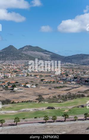 Landschaft mit grünem Golfplatz und Dorf auf der kargen Insel, im hellen Herbstlicht auf der Insel Porto Santo, Portugal Stockfoto