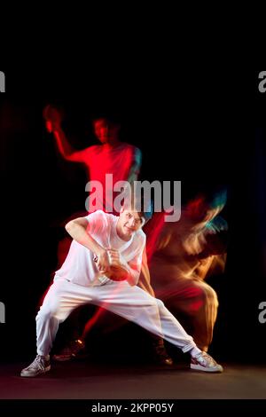 Junger Mann spielt Tischtennis in gemischtem Neonlicht Stockfoto